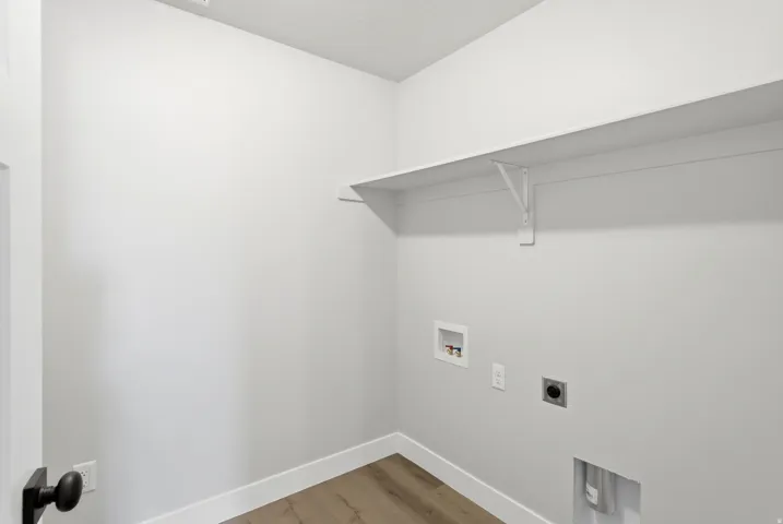 Laundry area featuring electric dryer hookup, light wood-style floors, and washer hookup