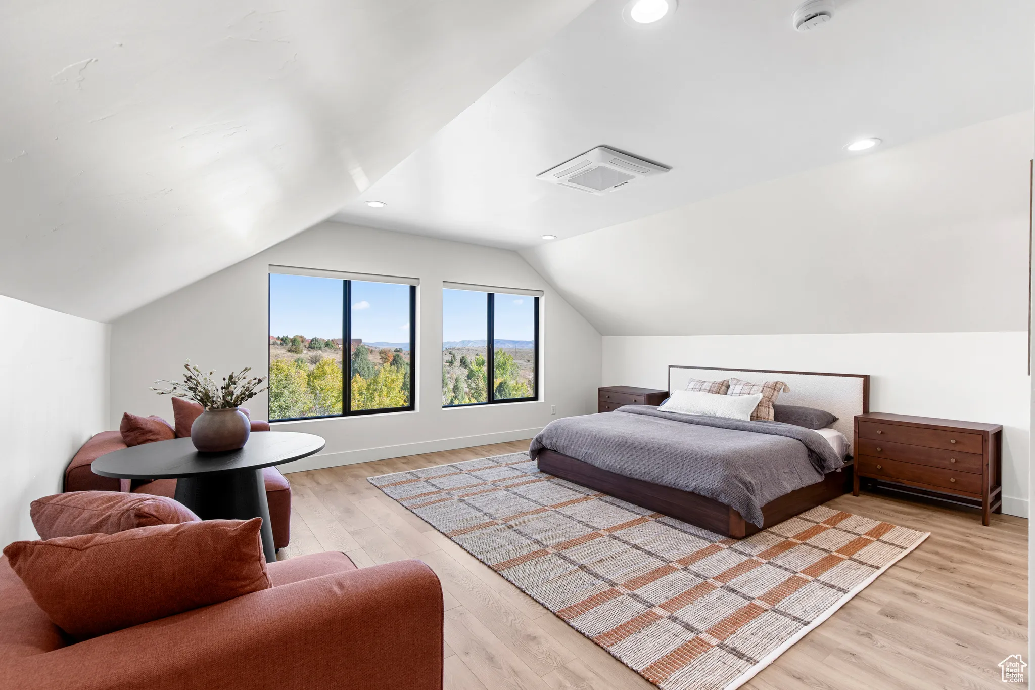 Bedroom with lofted ceiling and light wood finished floors