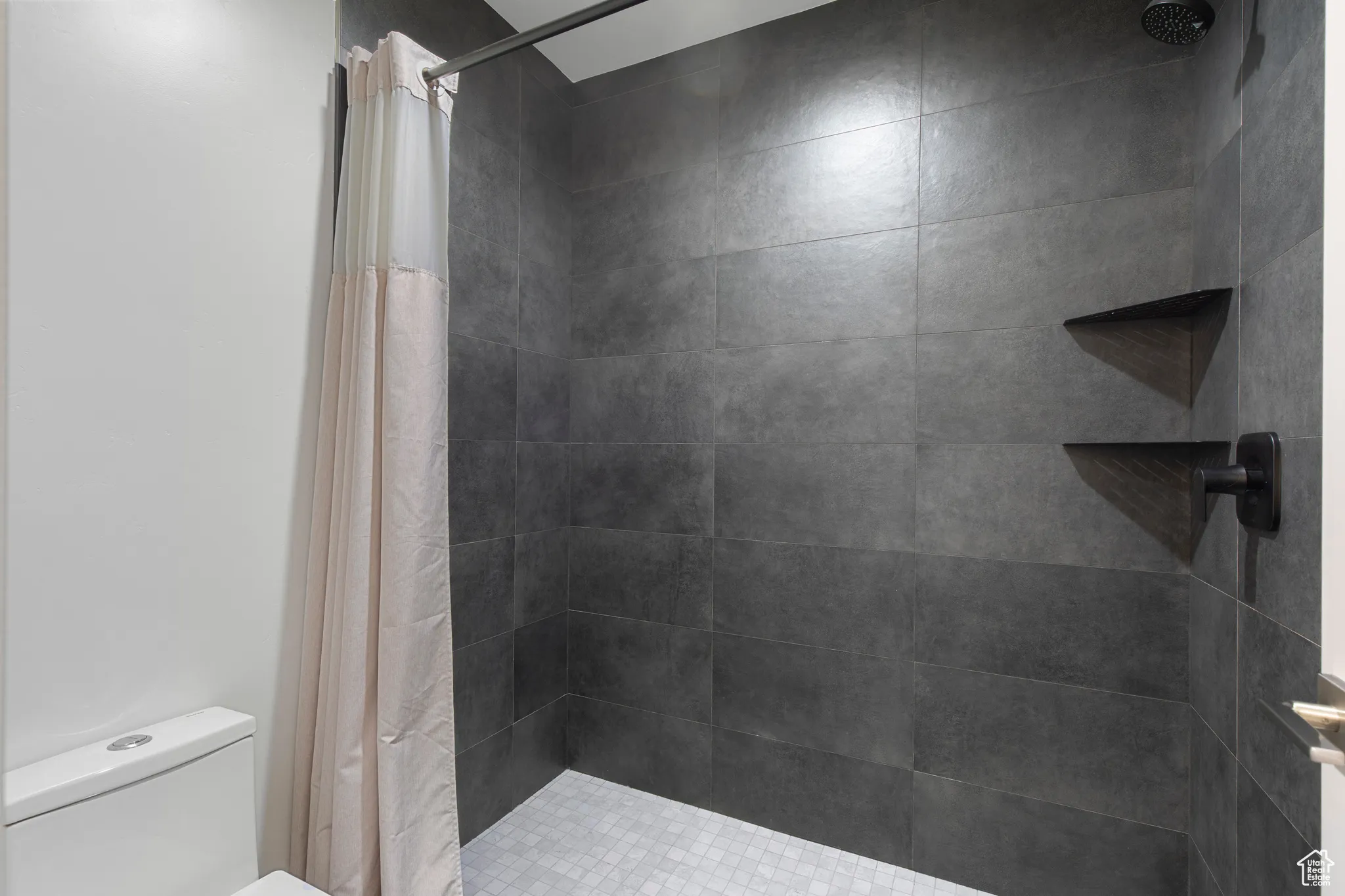 Bathroom featuring a shower stall and toilet