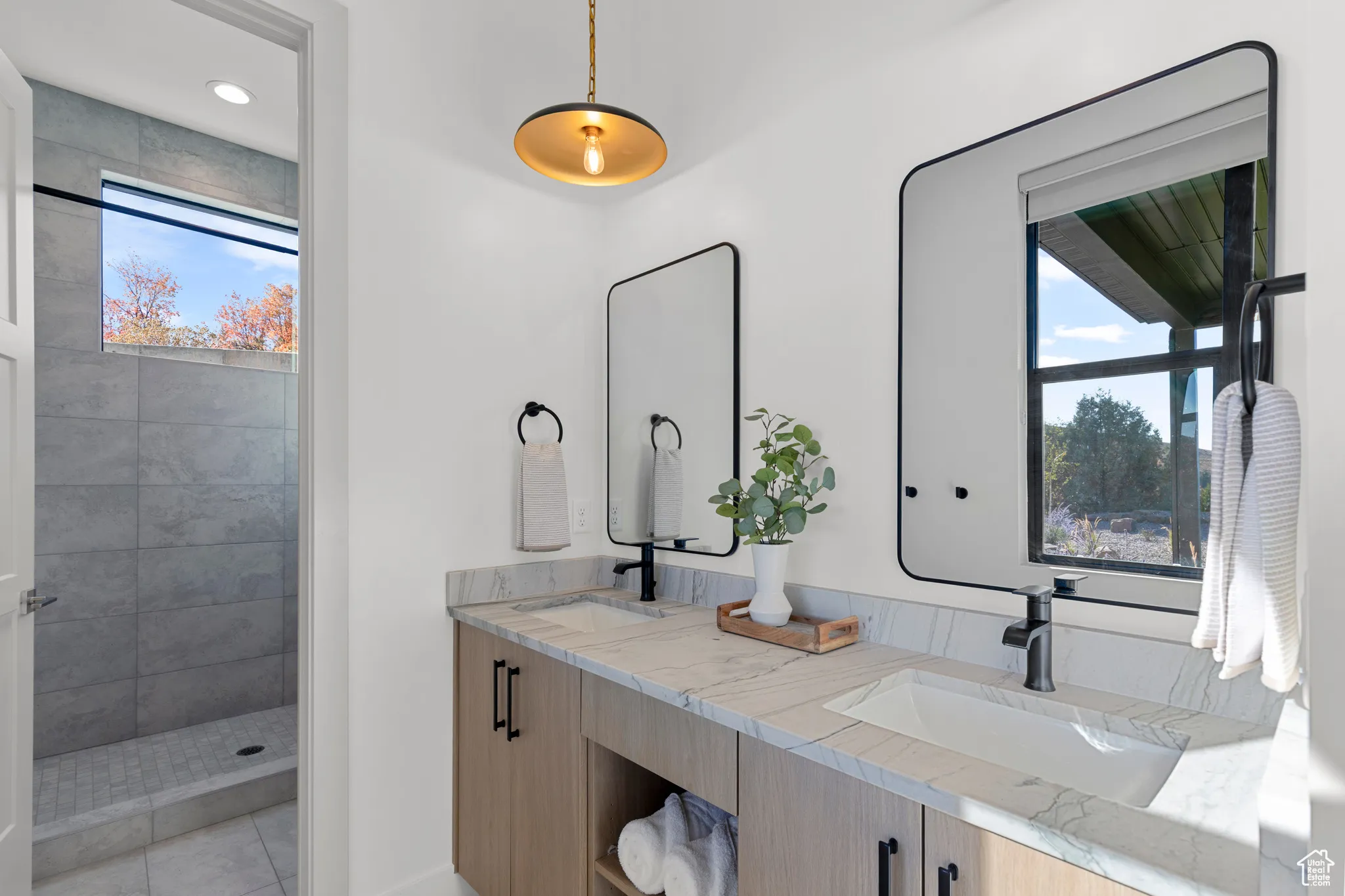 Full bath with double vanity and tiled shower