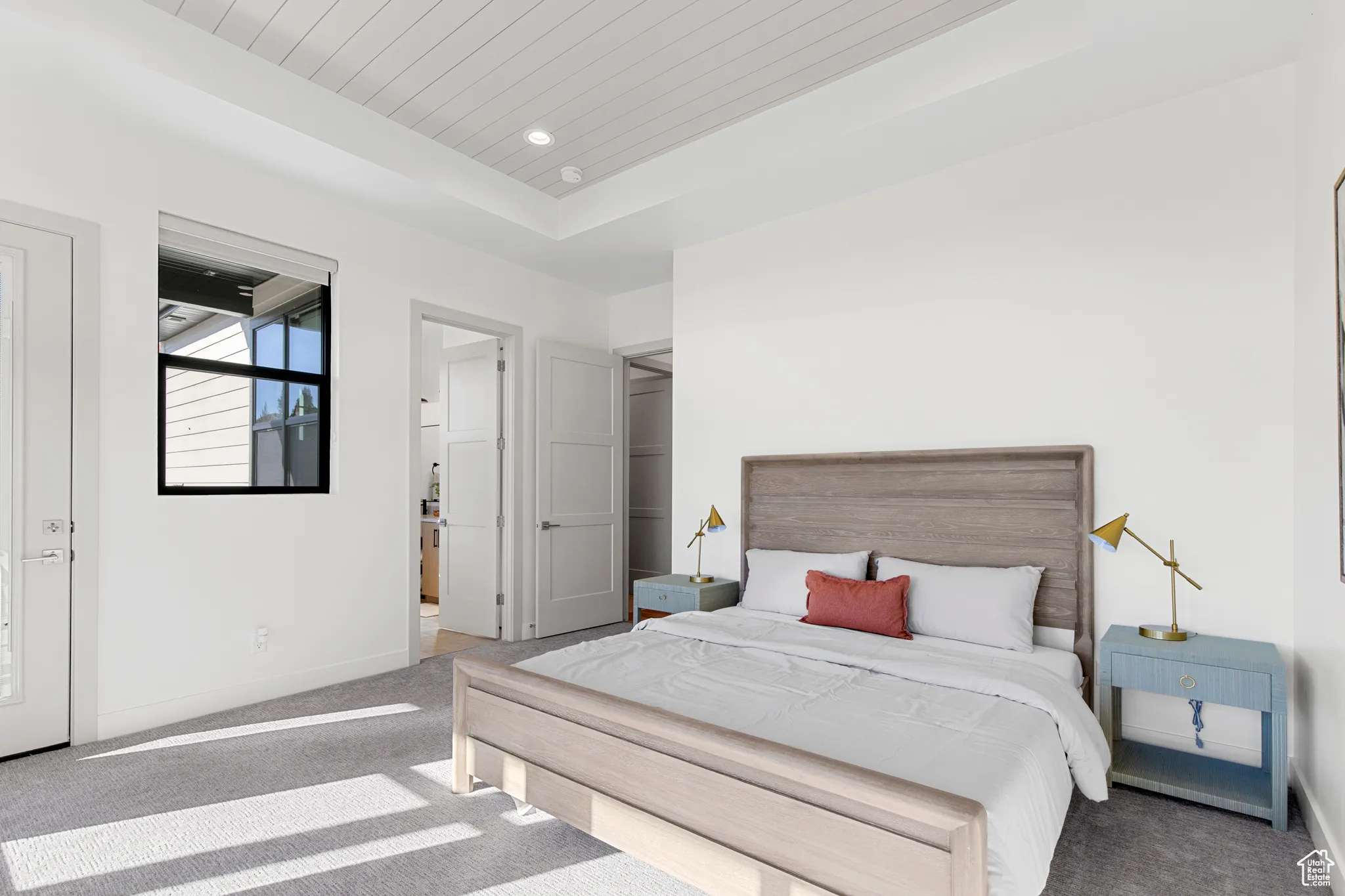 Carpeted bedroom with a raised ceiling, recessed lighting, and wood ceiling