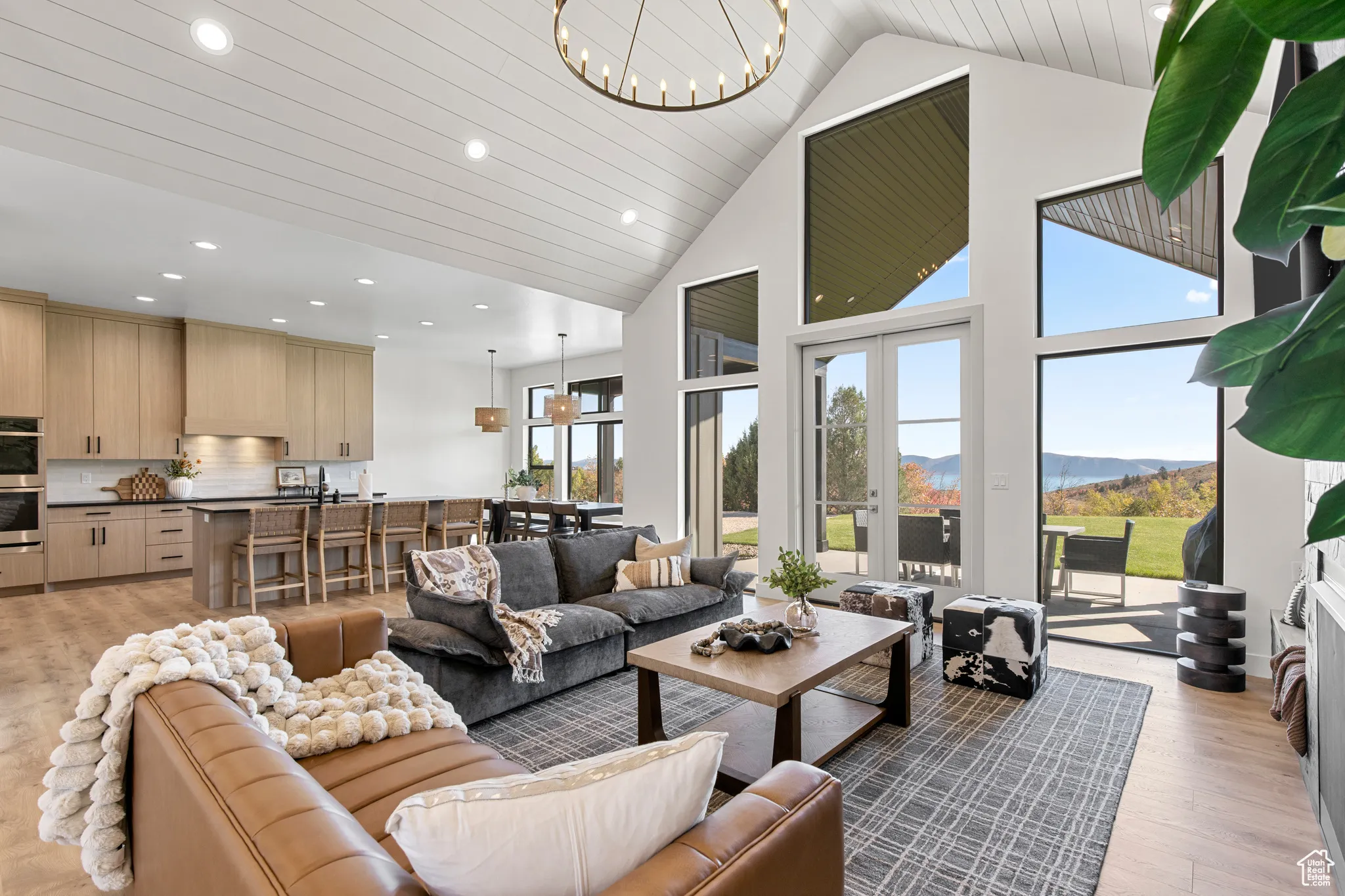 Living area with light wood-style flooring, high vaulted ceiling, a chandelier, a mountain view, and recessed lighting