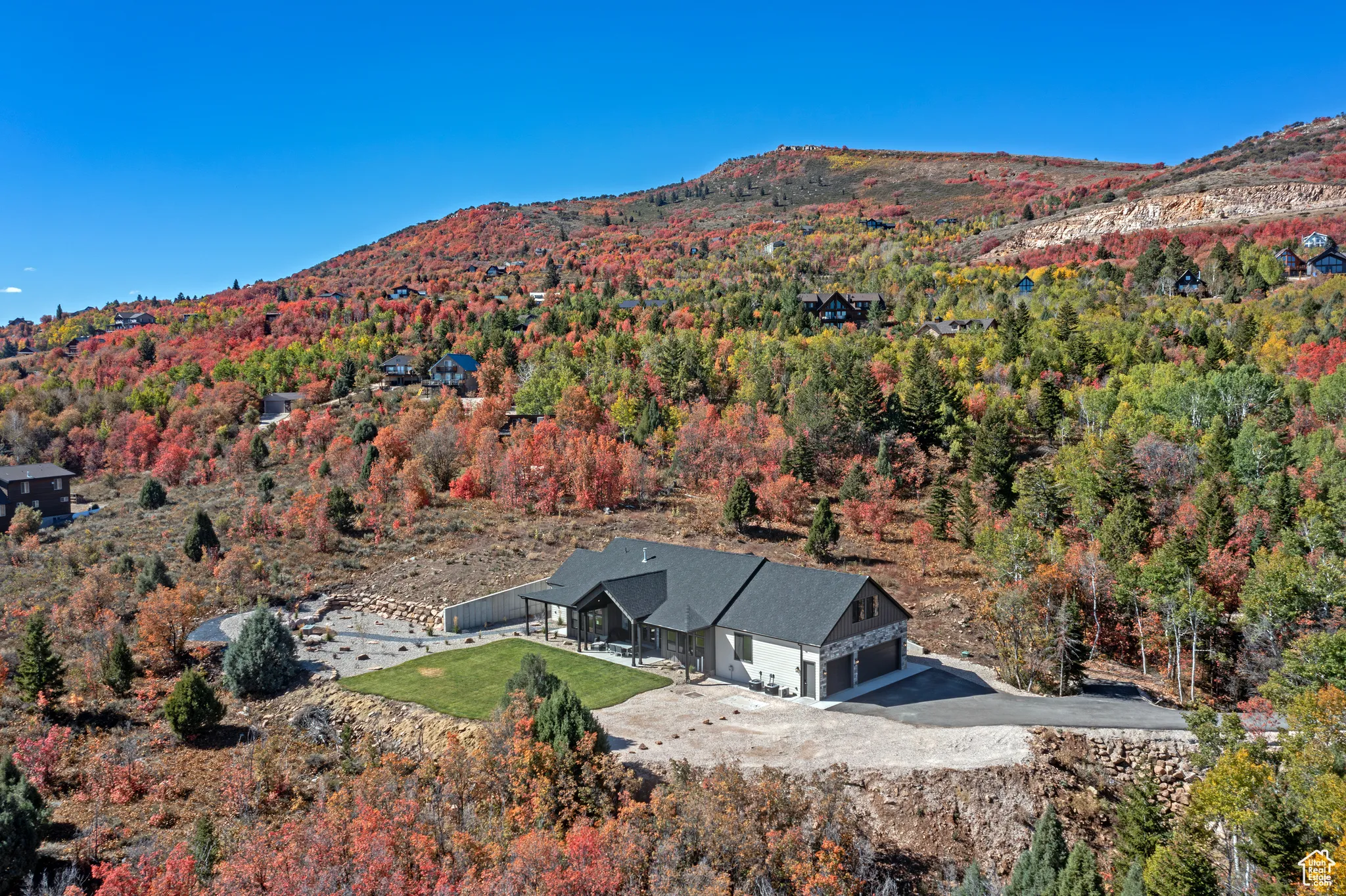 View of subject property featuring a mountain backdrop and a heavily wooded area
