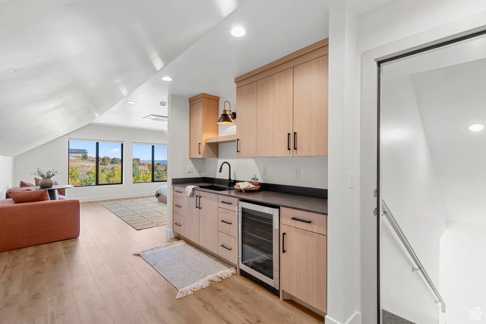 Indoor wet bar with light brown cabinetry, open shelves, recessed lighting, wine cooler, and light wood-style flooring