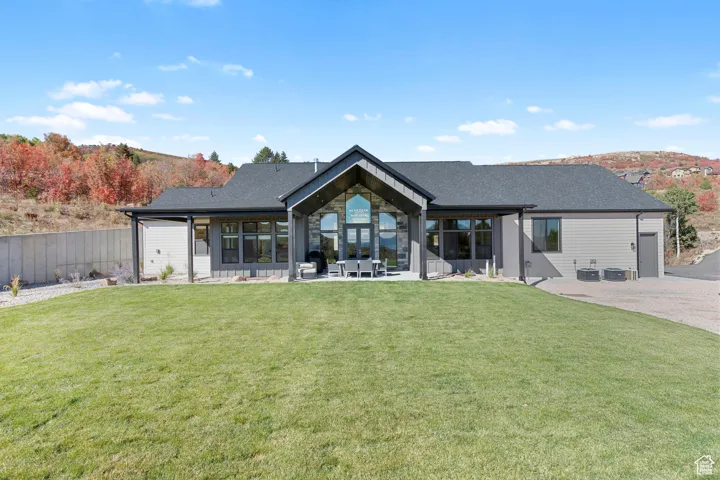 Back of property with a lawn and a patio area