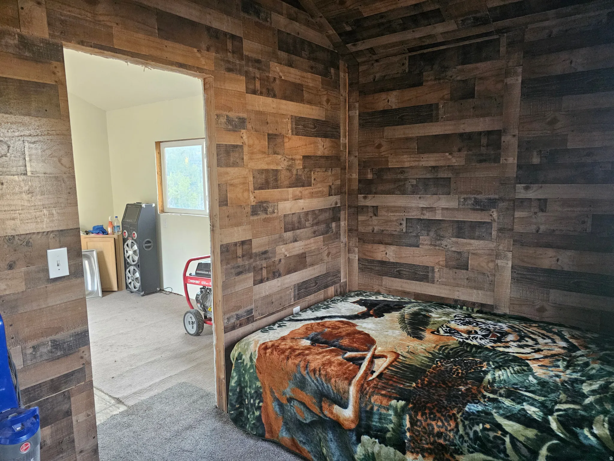 Bedroom featuring wooden walls and vaulted ceiling