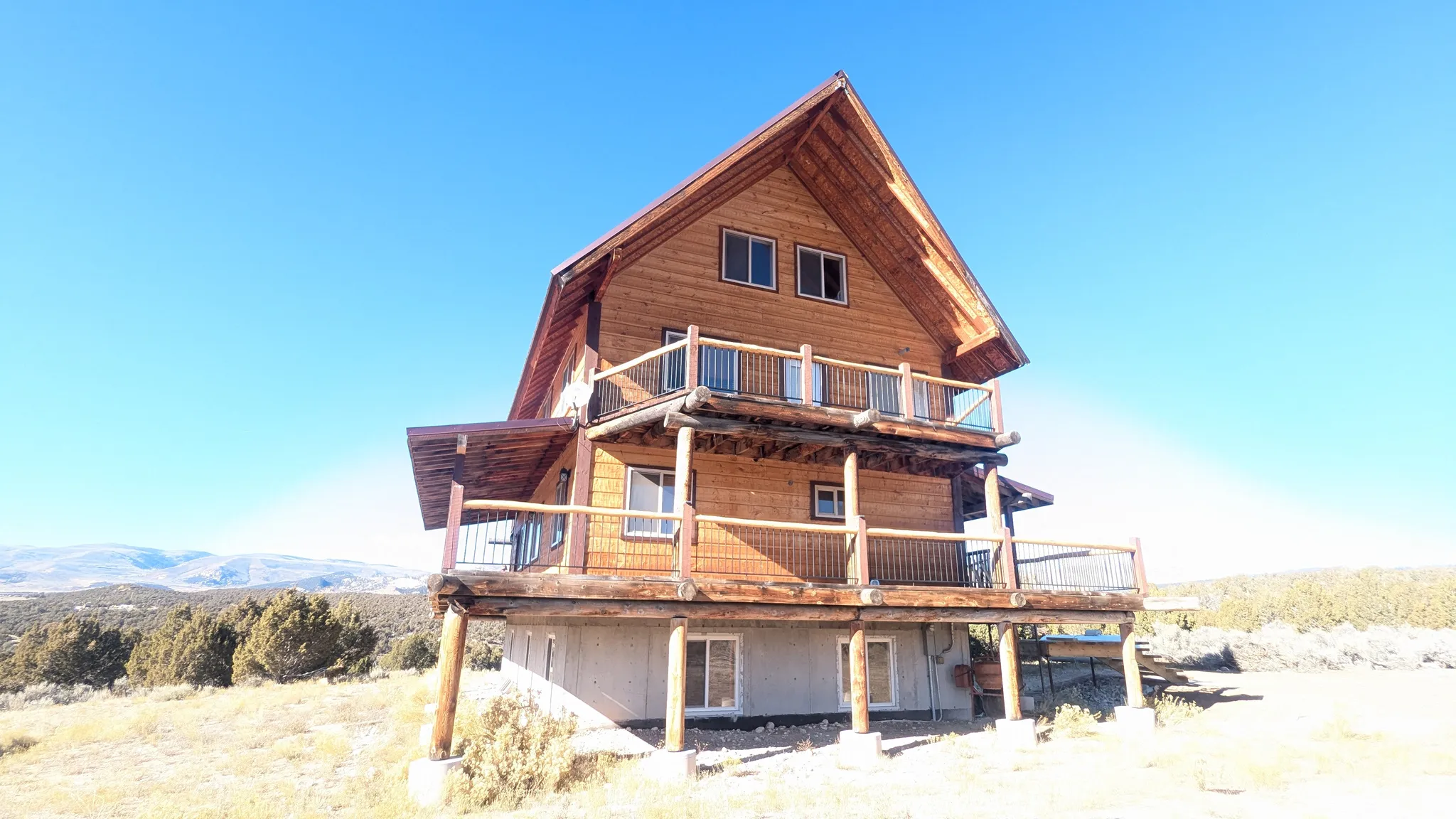 Back of house with a deck with mountain view and a balcony