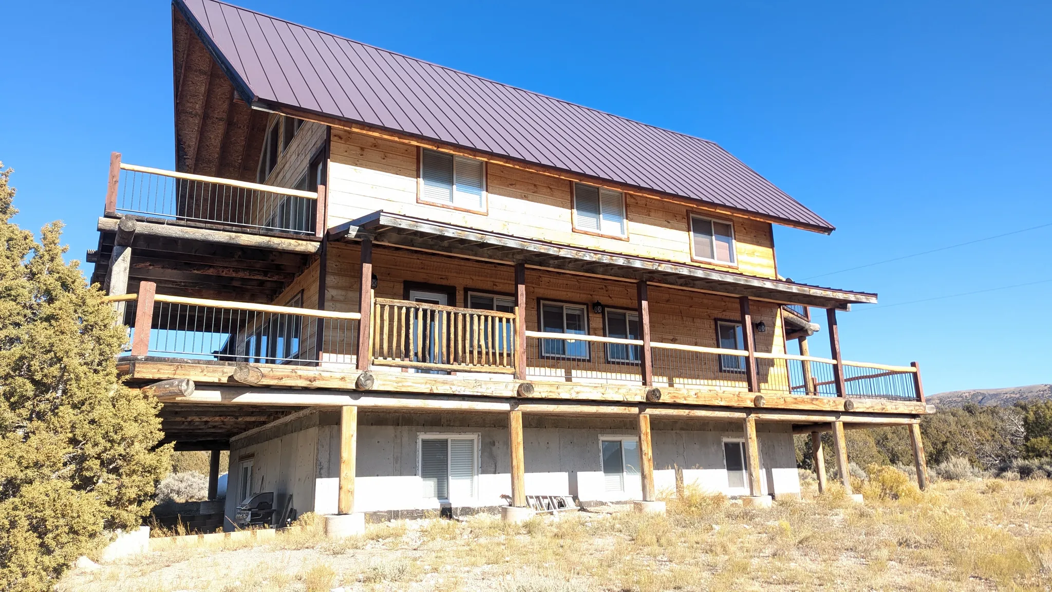 Back of house with a metal roof and a balcony