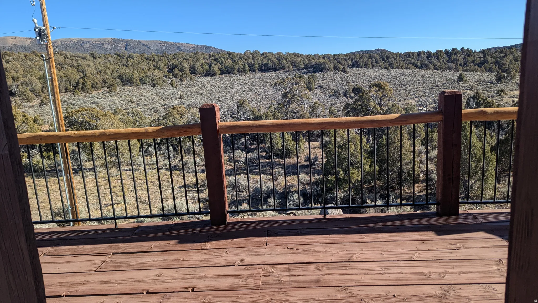 Wooden terrace featuring a view of trees