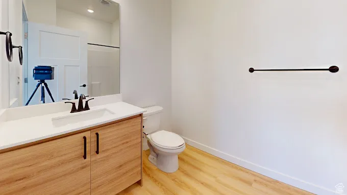 Bathroom featuring toilet, hardwood / wood-style flooring, and vanity