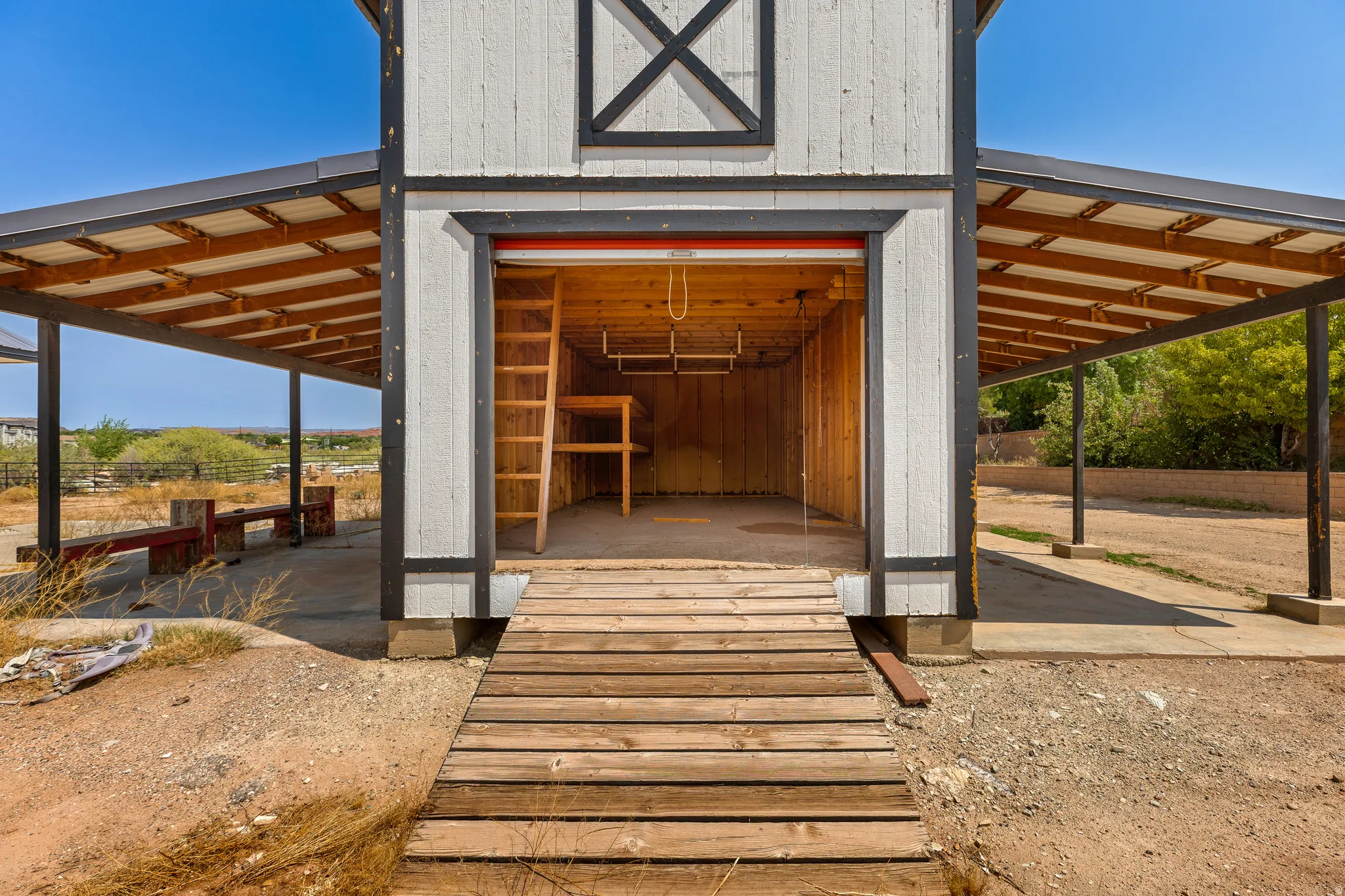 Poured concrete floor, built-in shelving, and a fixed ladder to the upper loft. A working barn that's finished, not framed.
