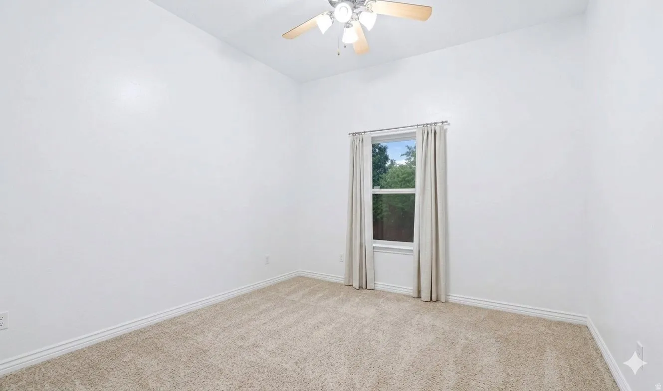 Additional bedroom, carpeted and light-filled.