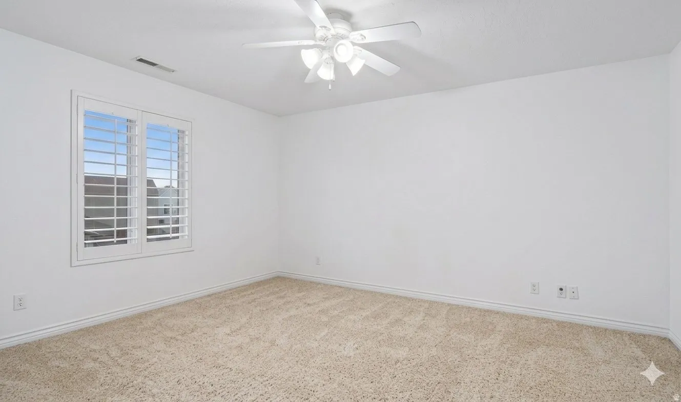 Bright upstairs bedroom with plantation shutters.