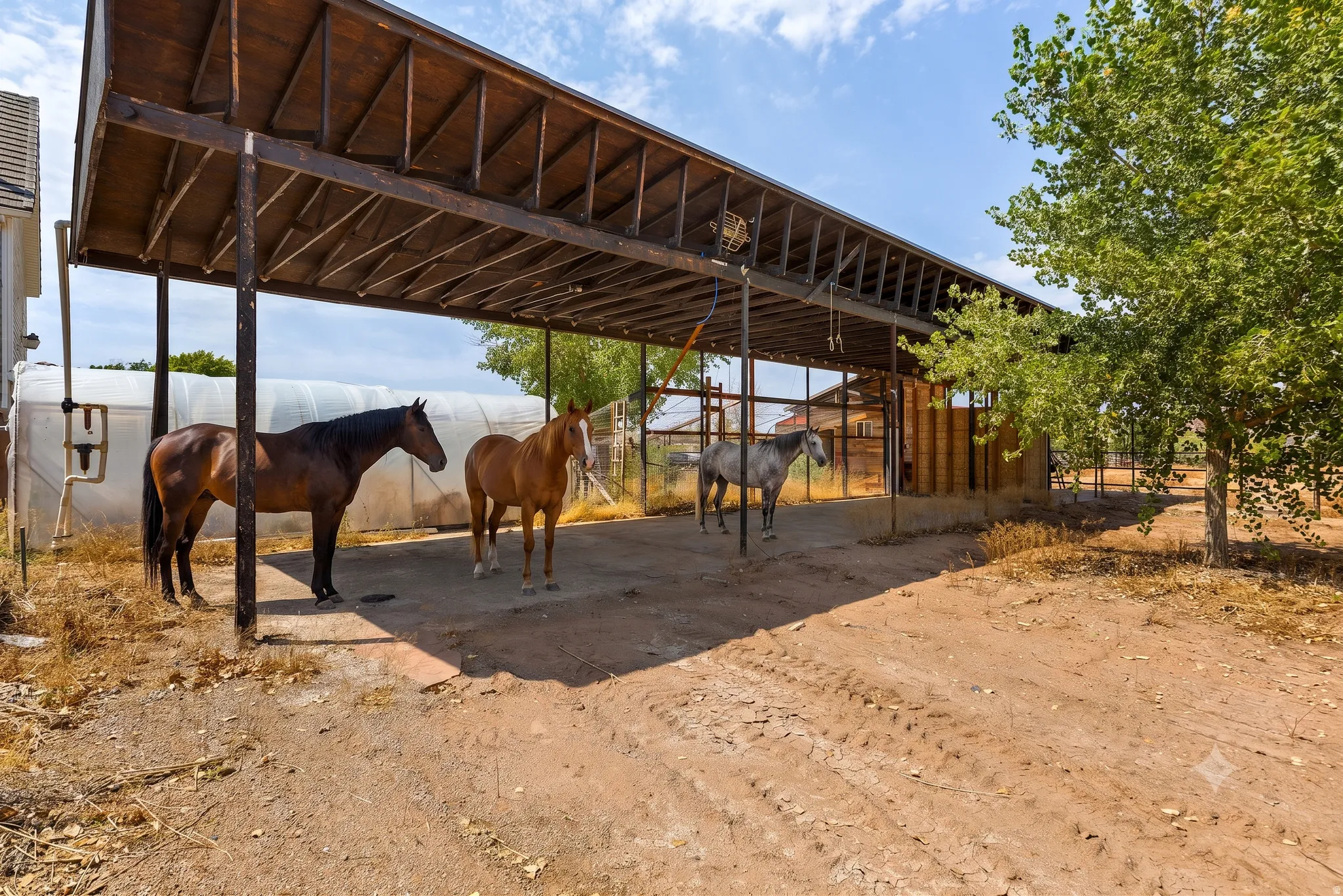 Deep covered span with room to pull a trailer through, stack hay, and park equipment — all under cover, all out of the Southern Utah sun.
