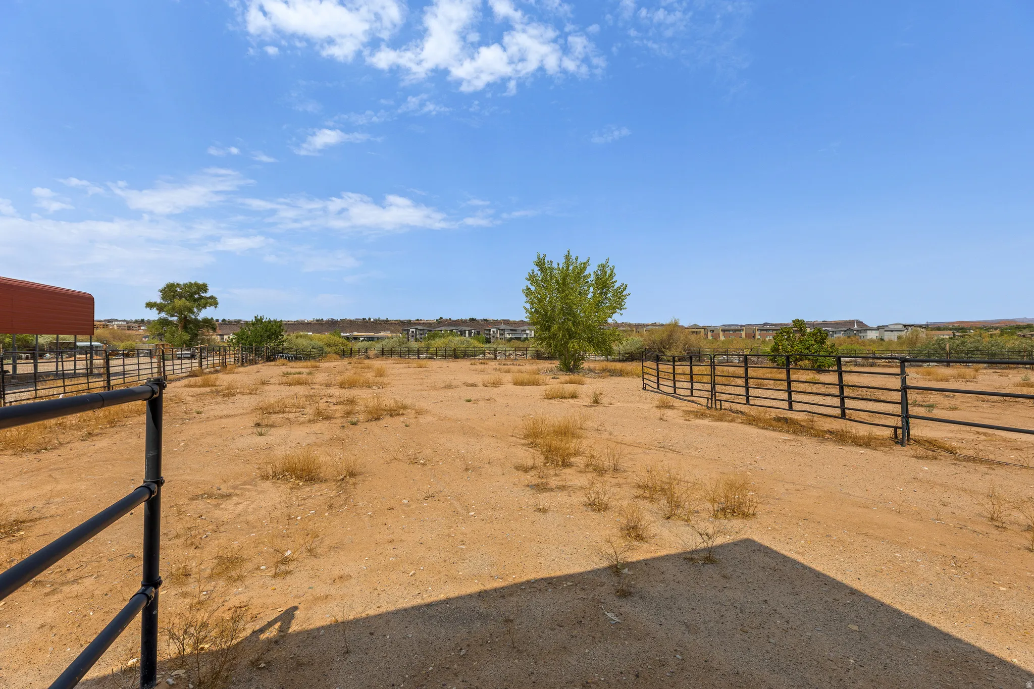 Pipe rail perimeter, level footing, and a mature shade tree. Usable turnout, not just acreage on paper.
