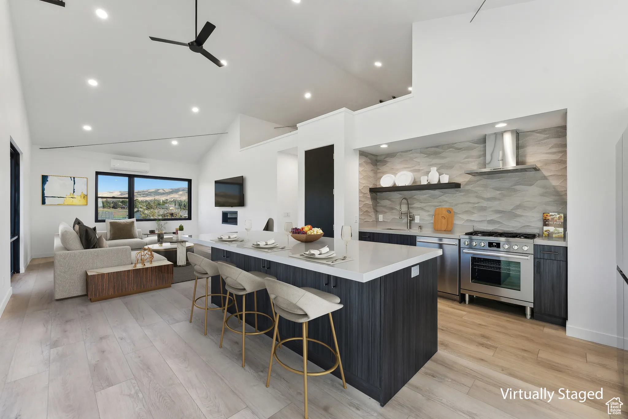 Kitchen with a center island, light hardwood / wood-style floors, appliances with stainless steel finishes, and wall chimney range hood