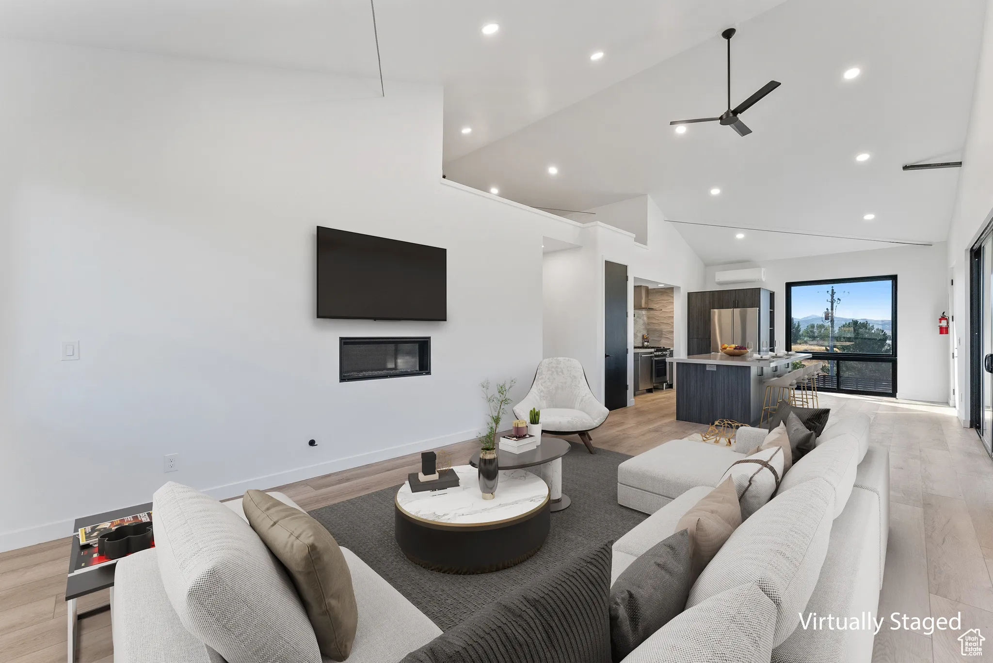 Living room featuring ceiling fan, a wall mounted air conditioner, light hardwood / wood-style floors, and high vaulted ceiling