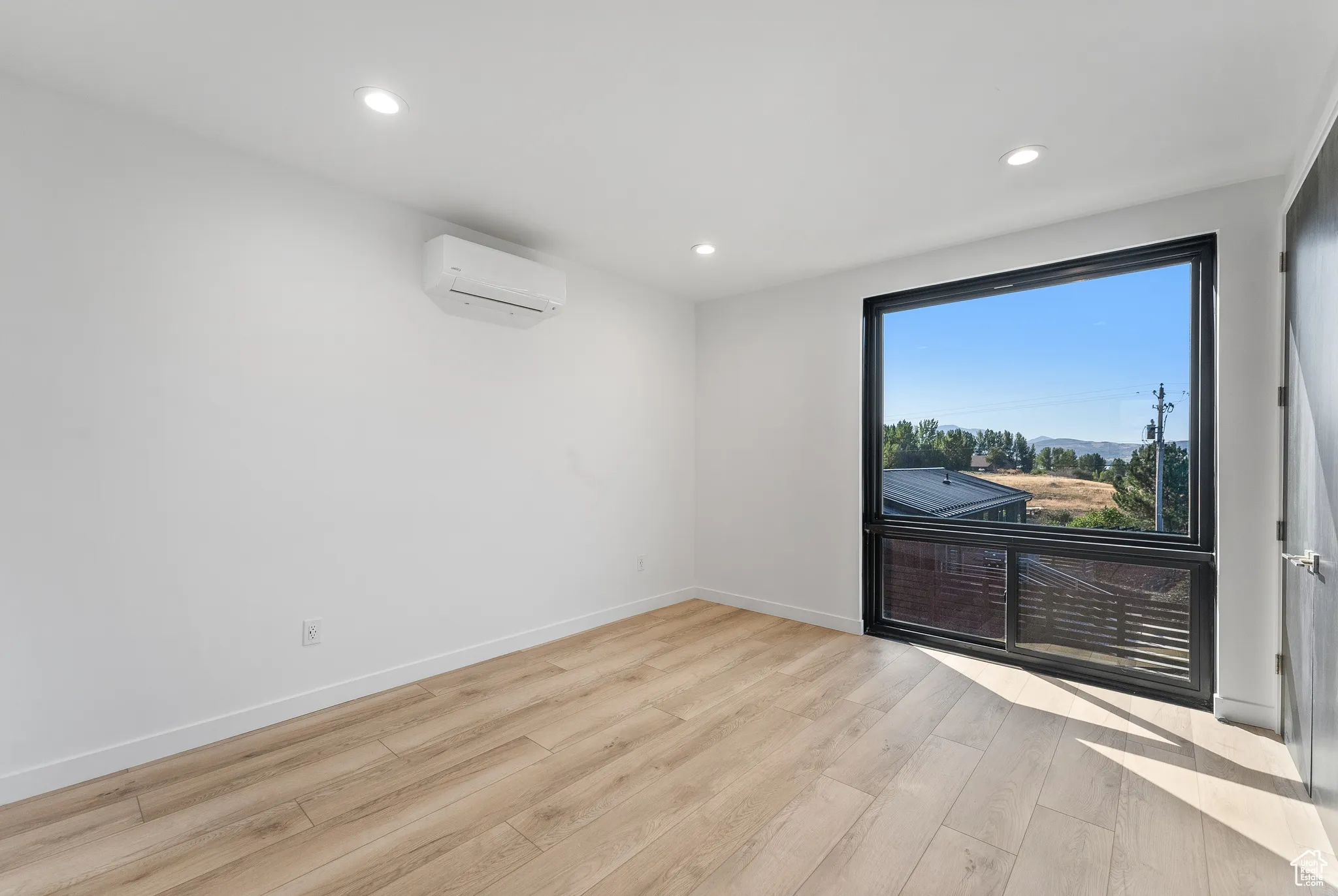 Spare room featuring light hardwood / wood-style flooring and a wall unit AC