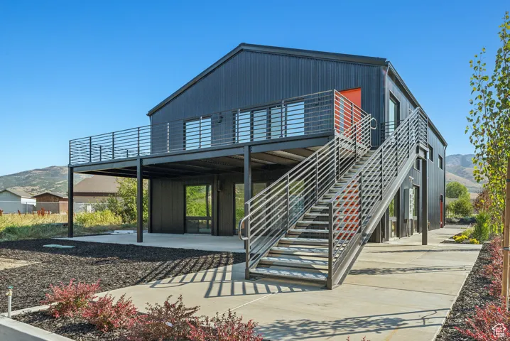 Rear view of property featuring a deck with mountain view and a patio