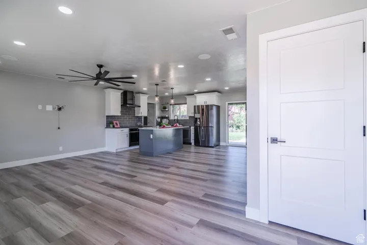 Unfurnished living room featuring light hardwood / wood-style floors, sink, and ceiling fan