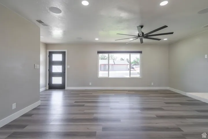 Interior space with ceiling fan and dark hardwood / wood-style floors