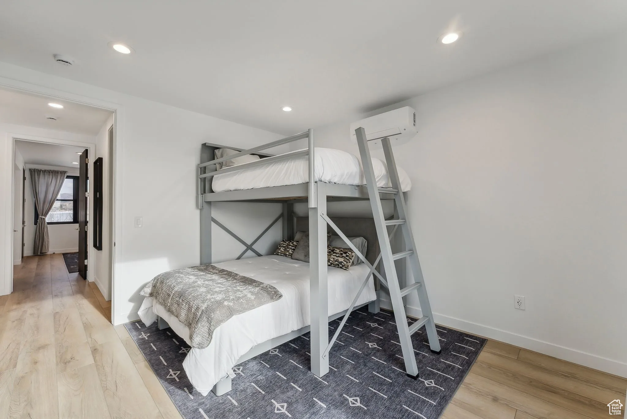 Bedroom with hardwood / wood-style flooring and an AC wall unit