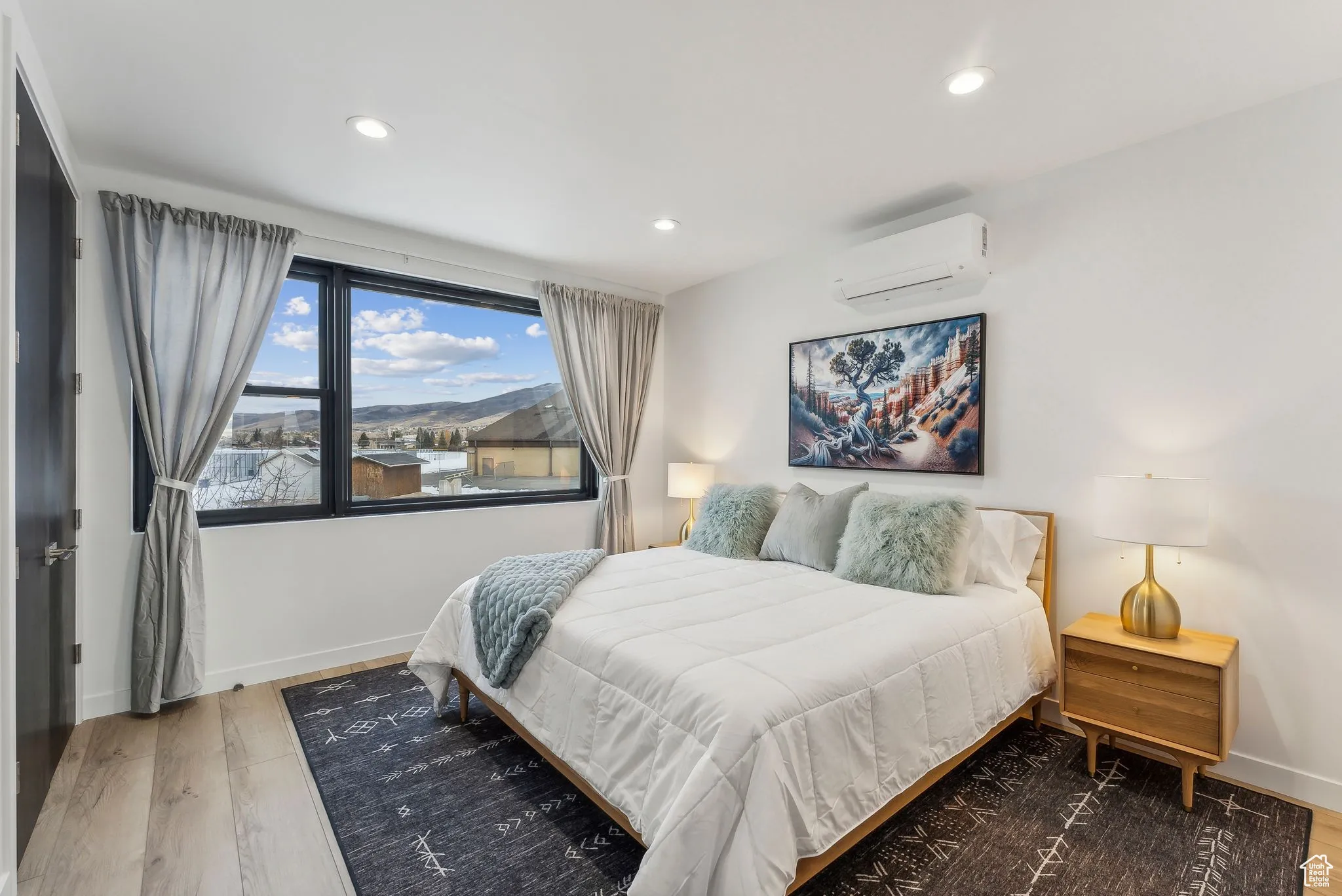 Bedroom featuring a wall mounted air conditioner and hardwood / wood-style flooring
