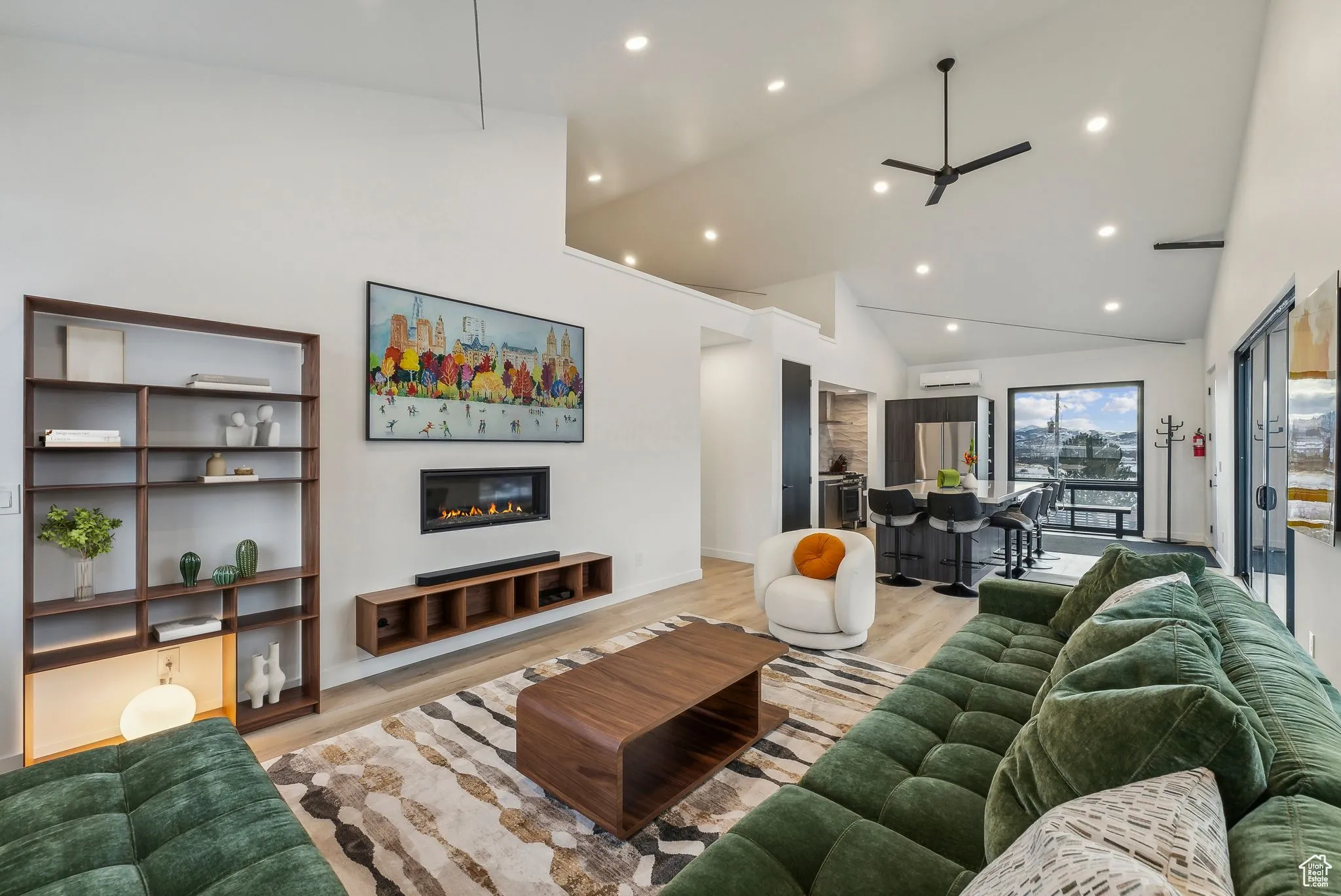 Living room featuring ceiling fan, light hardwood / wood-style floors, high vaulted ceiling, and a wall mounted AC