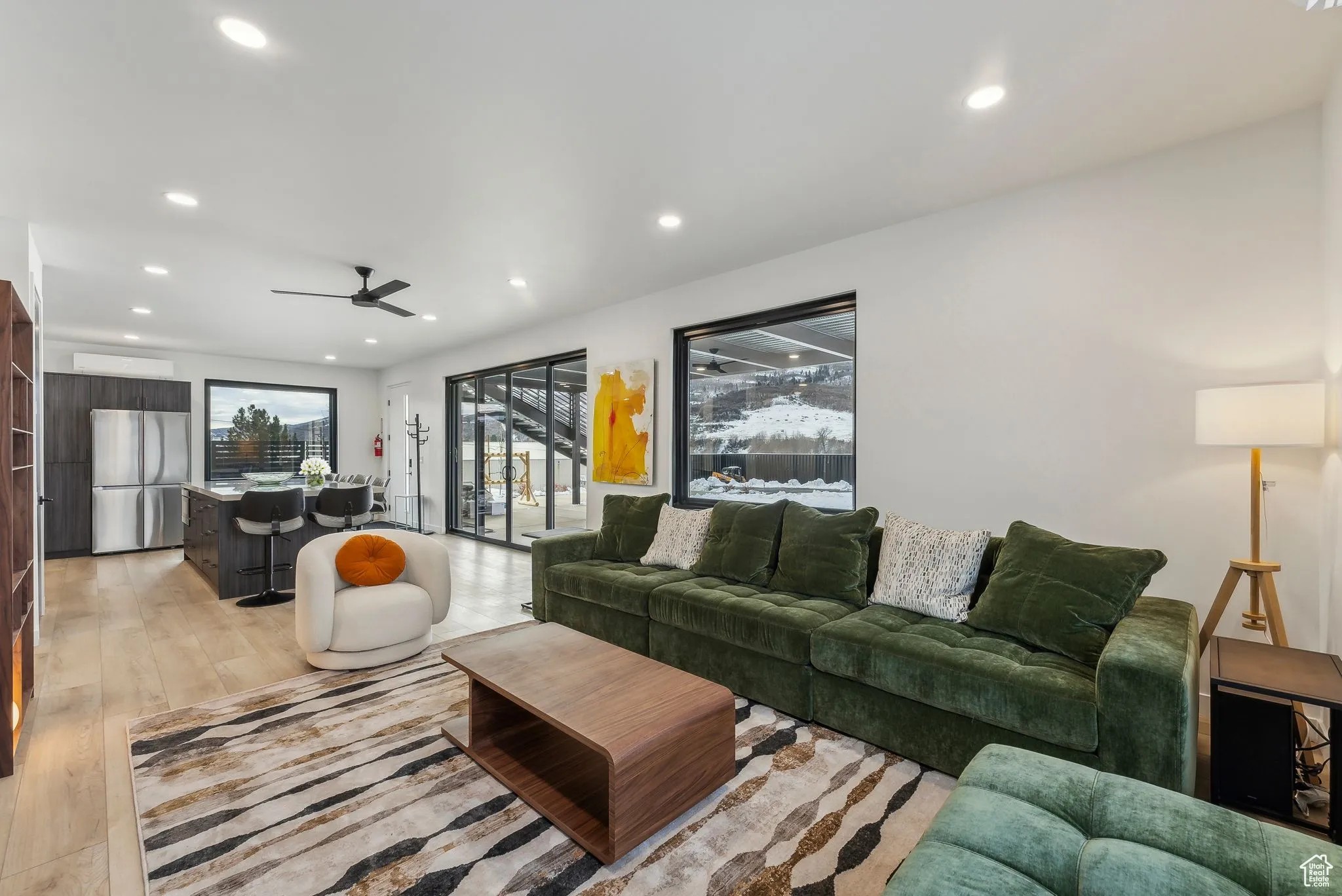 Living room with ceiling fan and light hardwood / wood-style flooring