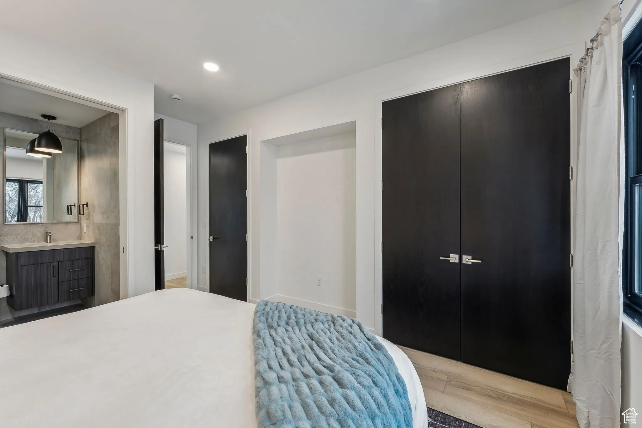 Bedroom featuring connected bathroom, light hardwood / wood-style floors, and a closet