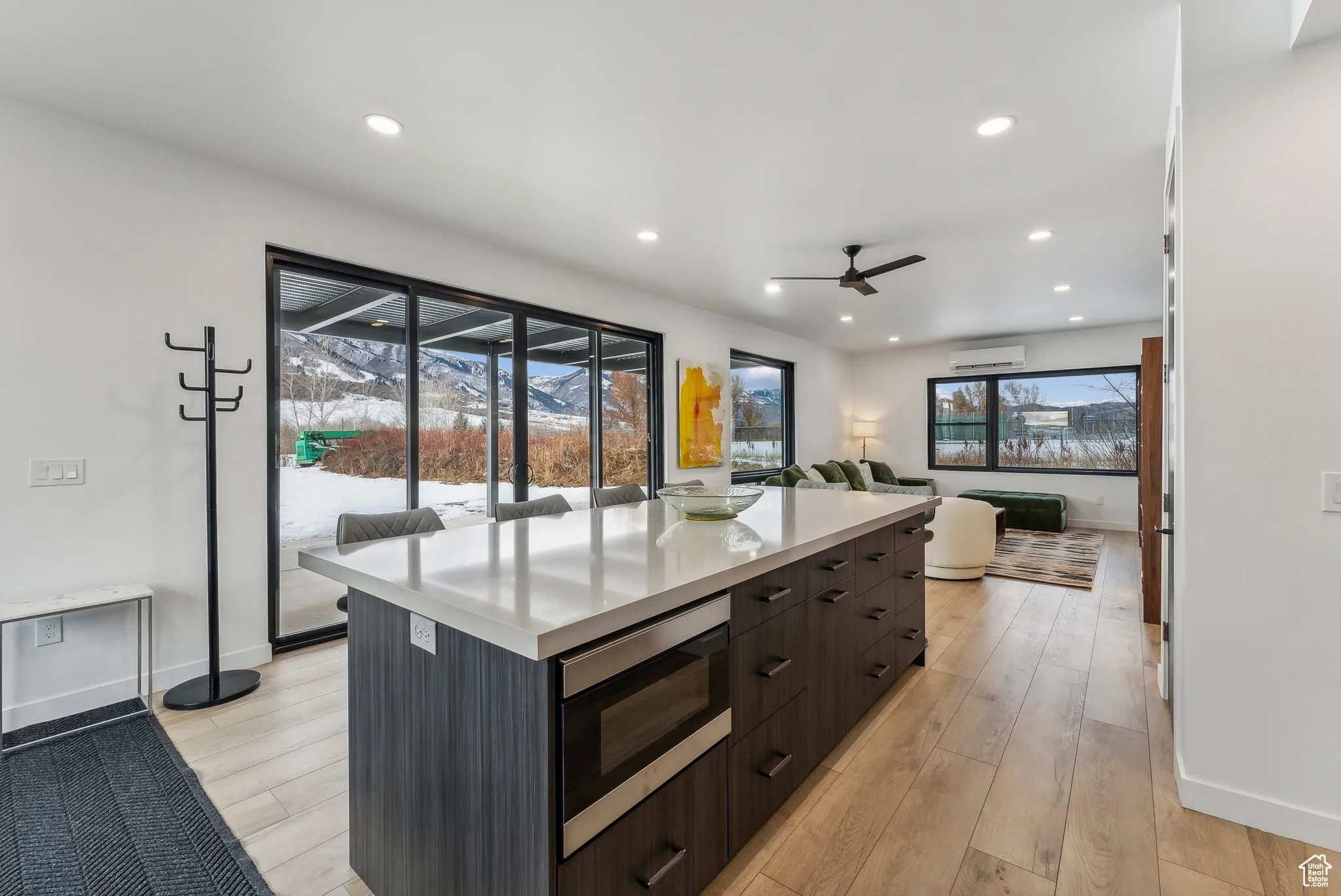 Kitchen with a center island, a healthy amount of sunlight, stainless steel microwave, and light wood-type flooring