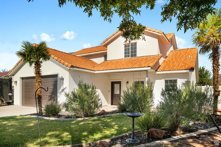 Mediterranean / spanish-style home featuring a front yard and a garage
