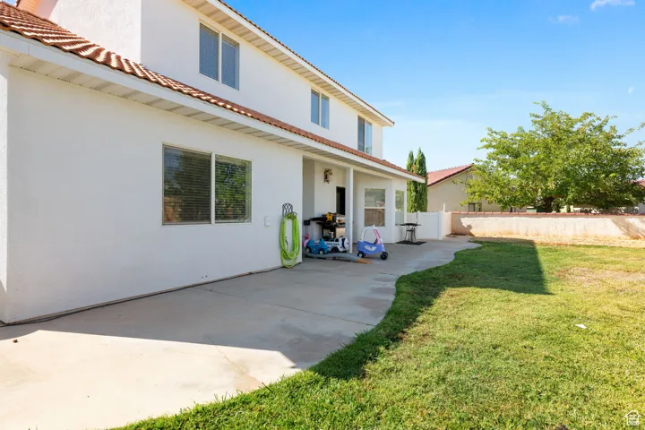 Rear view of property with a patio area and a yard