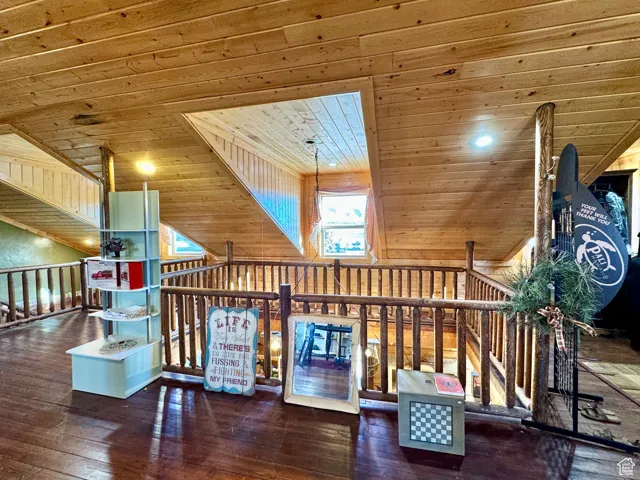 Interior space with wooden walls, dark hardwood / wood-style flooring, and wood ceiling
