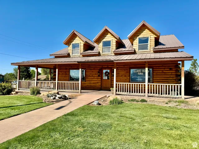 Cabin with a porch and a front lawn