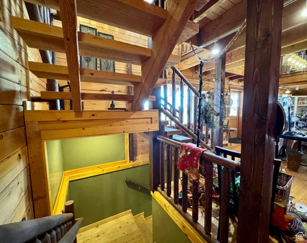 Stairway featuring wood walls and hardwood / wood-style flooring