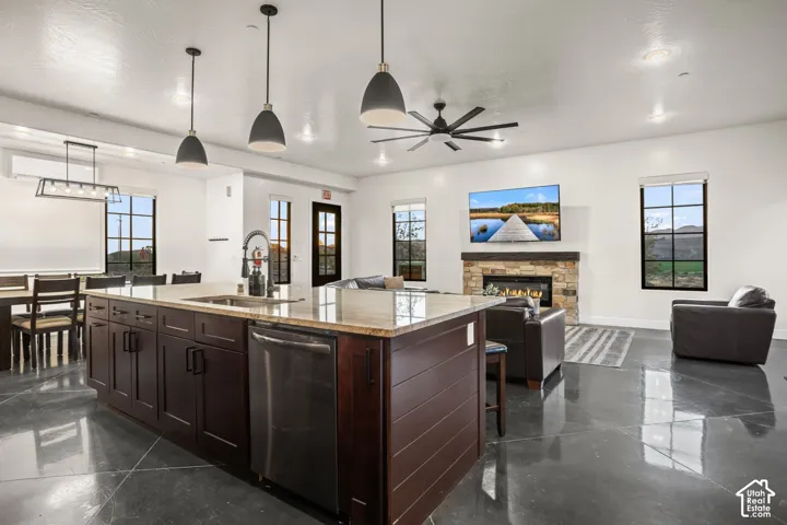 A granite-topped island anchors the kitchen and opens to the great room, with polished concrete floors across the main level.