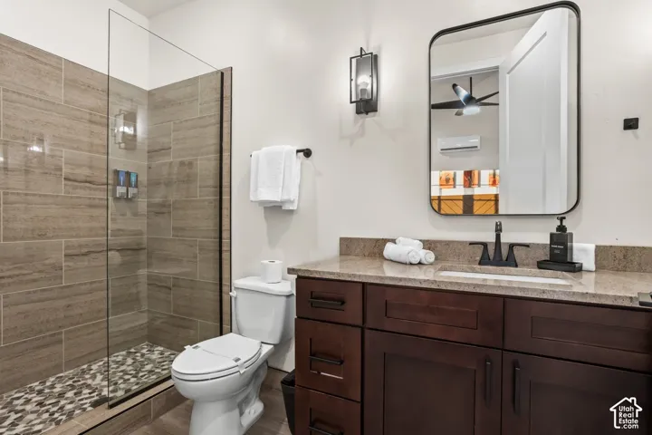 Another full bath with a walk-in tile shower and a wood vanity.