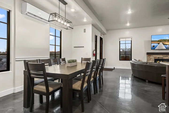 A long dining table seats the group, open to the great room on the polished concrete main floor.