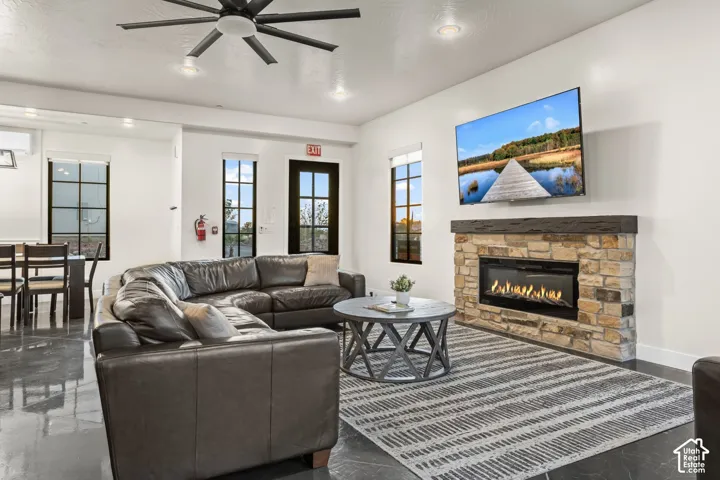 The great room gathers around a stone gas fireplace and a big mounted TV, with a sectional that seats the whole crew.