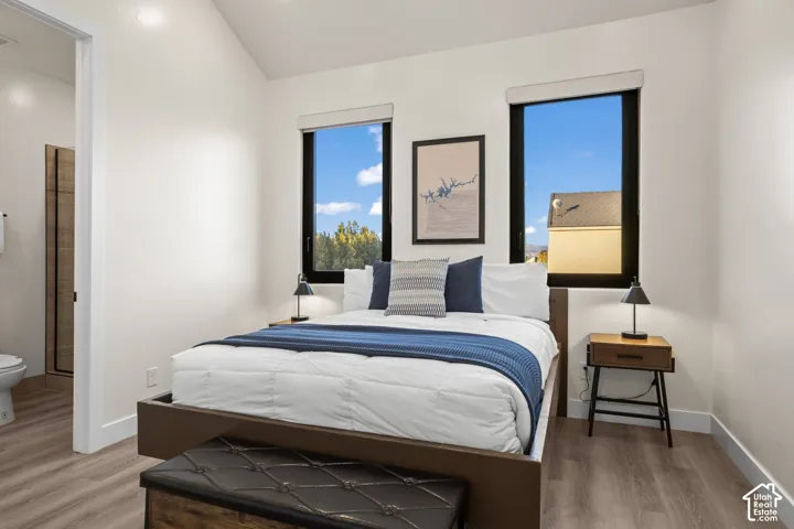 A bright bedroom with windows on two walls.