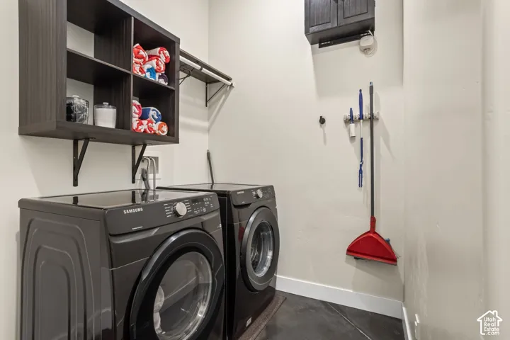 A laundry room with a front-load washer and dryer, plus storage shelving.