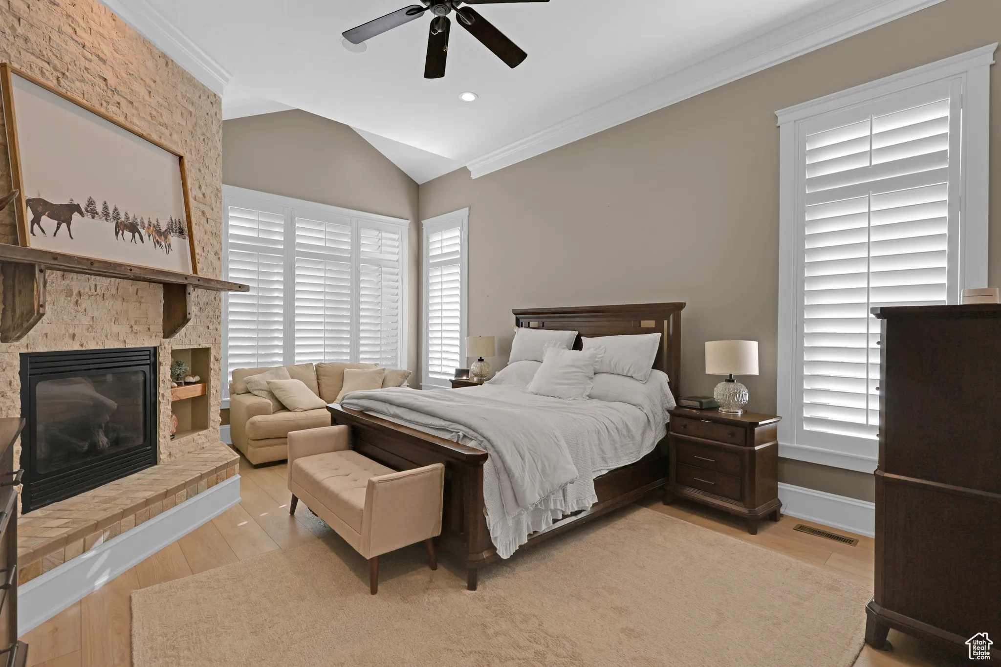 Master bedroom with light hardwood / wood-style floors, multiple windows, and ceiling fan