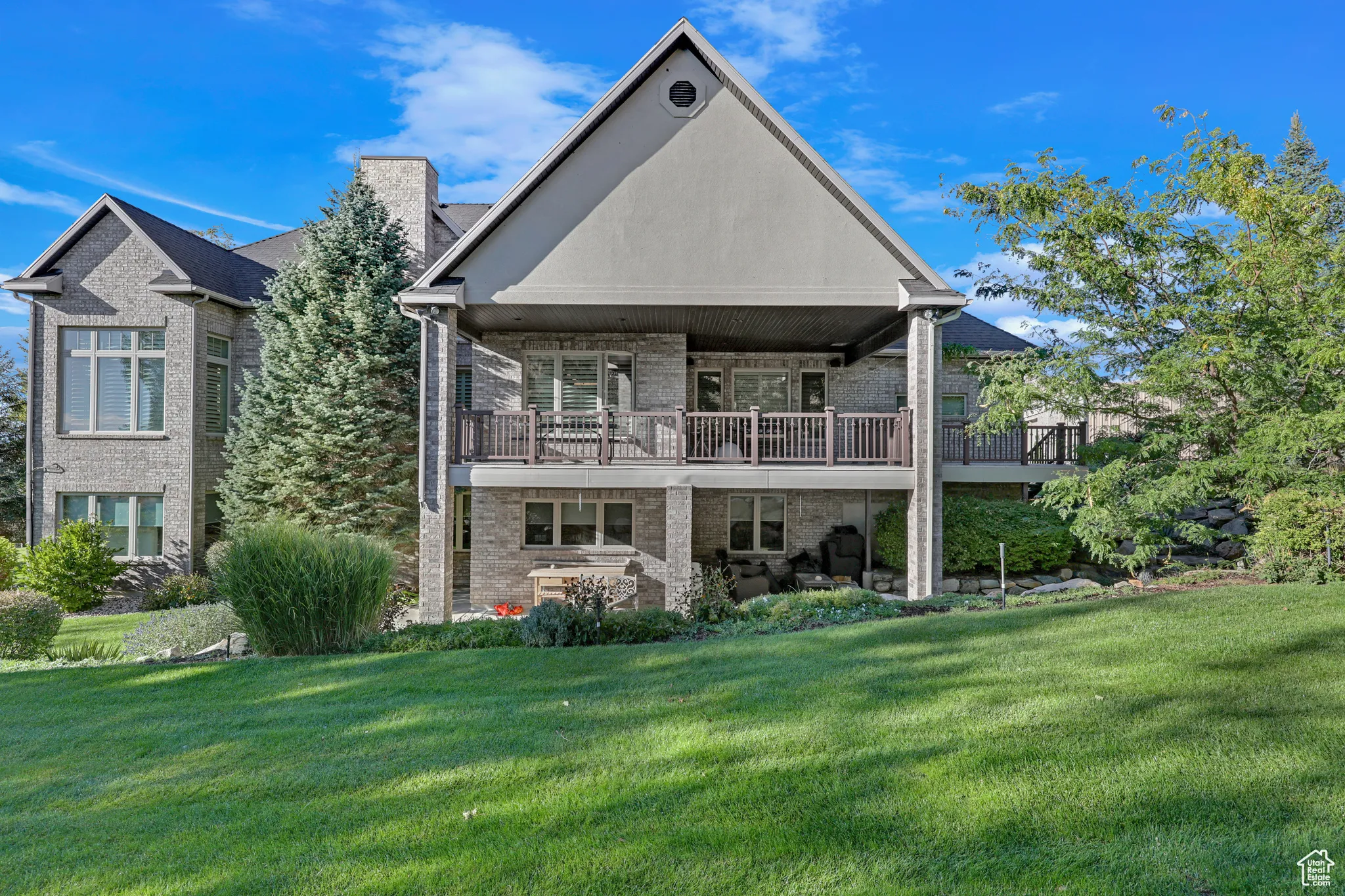Rear view of property with deck and lawn