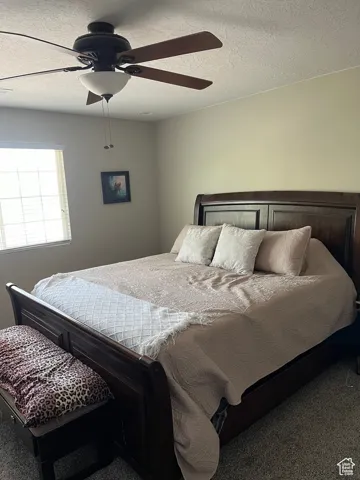 Primary bedroom with ceiling fan and King-sized bed