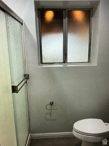 Basement Bathroom with toilet and a shower with door