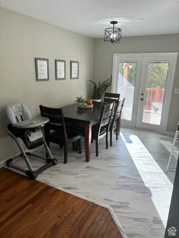Dining room featuring a chandelier, french doors, a textured ceiling, and LVP floors