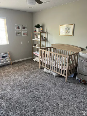 4th bedroom with a nursery area and ceiling fan