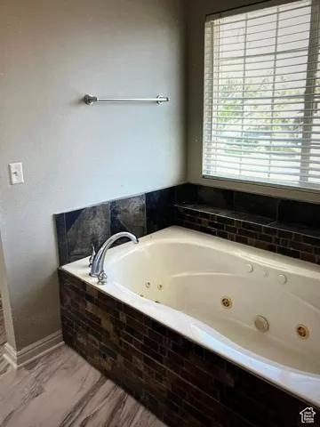 Primary Bathroom with tiled bath