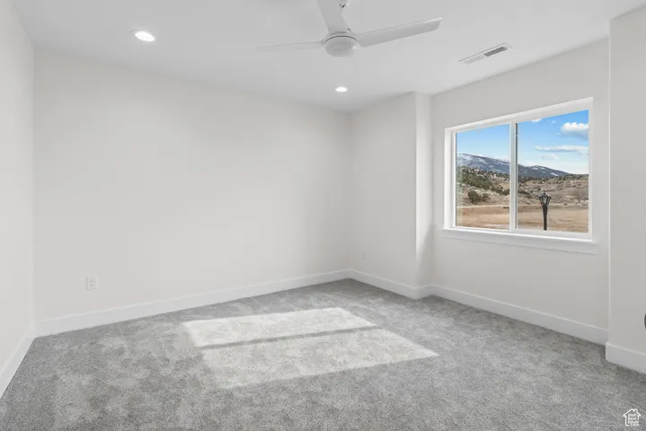 Unfurnished room featuring baseboards, visible vents, ceiling fan, carpet floors, and recessed lighting